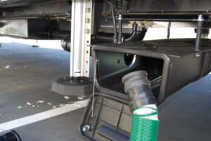 Waste Master® Sewer Hose connecting through storage enclosure.
